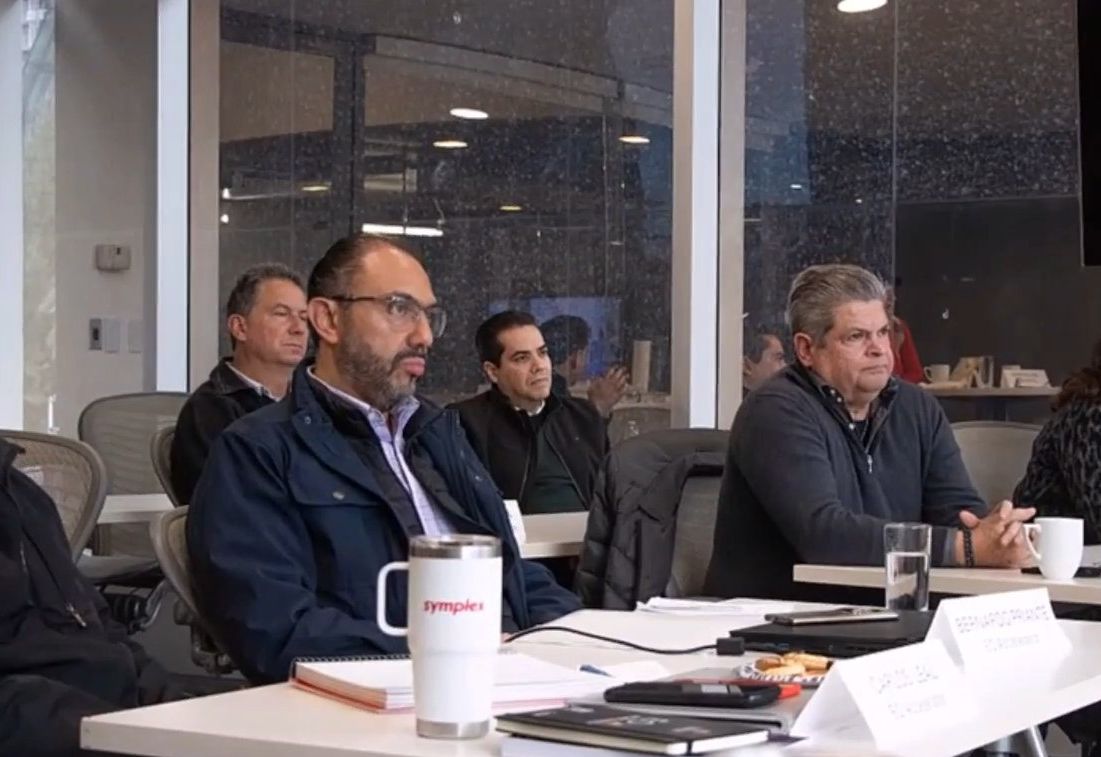 Sesión de trabajo de EO Accelerator Monterrey: dueños de empresa alrededor de la mesa con sus cuadernos y sus letreros de nombre